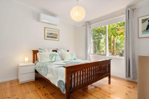 a bedroom with a bed and a large window at Pet Friendly Island Garden Retreat in Cowes in Cowes