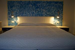 a bedroom with a bed with a blue wall at Hotel Miramare in Bosa Marina