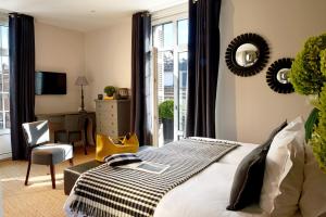 een slaapkamer met een bed, een tafel en een stoel bij Hôtel Le Fer à Cheval in Trouville-sur-Mer
