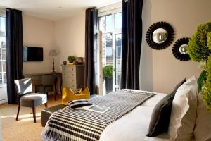 a bedroom with a bed and a table and a chair at Hôtel Le Fer à Cheval in Trouville-sur-Mer