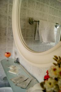 a bathroom with a sink and a mirror and a counter at Hotel Miramare in Bosa Marina