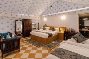 a large bedroom with two beds and a mirror at Desert Galaxy Camp - A Family Luxury Camp in Jaisalmer