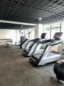 a row of treadmills in a gym with a row of treadms at The Loftel in Ruaka