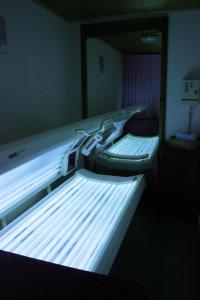 two empty beds in a room with lights on at Hotel Molino in Falcade