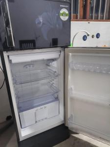 an empty refrigerator with its door open in a kitchen at Minsara Villa in Ahangama