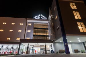 una vista nocturna de un hotel con un cartel en Hiber Hotel - Acesso a Chapecó, en Chapecó