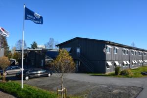 un edificio nero con una macchina parcheggiata in un parcheggio di Hotell Entré Norr a Umeå