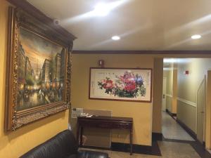 a living room with a painting on the wall at Flushing Motel in Queens