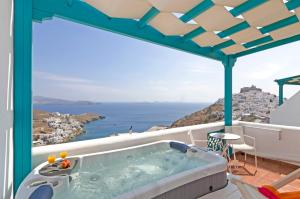 una vasca idromassaggio su un balcone con vista sull'oceano di Astypalaia Hotel Palace a Astypalaia Town