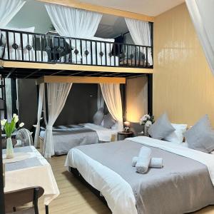 a bedroom with two beds and a loft at บ้านพักบุหงา199 อ สรรพยา in Sanphaya