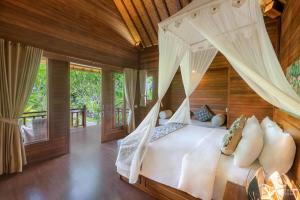 a bedroom with a bed with a canopy at Sunset Cave Villas Lembongan in Nusa Lembongan +84 photos