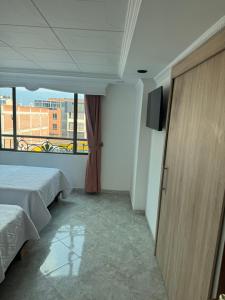 a hotel room with two beds and a window at Hotel Americas Suites in Bogotá