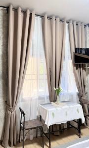 a table and chairs in front of a window with curtains at บ้านพักบุหงา199 อ สรรพยา in Sanphaya