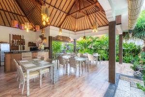 a dining area with tables and chairs and a kitchen at Sunset Cave Villas Lembongan in Nusa Lembongan