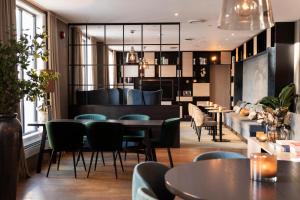 a restaurant with tables and chairs and a couch at Home Hotel Atlantic in Sandefjord
