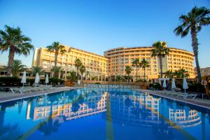 a large swimming pool in front of a hotel at Fame Residence Lara & Spa in Lara