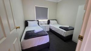 a small room with two beds and a window at The Prospect Executive Home in Prospect