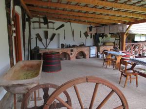 a large room with tables and chairs and a kitchen at Holló Vendégház in Szögliget