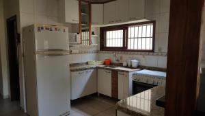 a kitchen with white appliances and a white refrigerator at Casa Perequê-Açu in Ubatuba