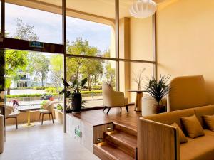 a living room with a couch and a large window at Peace Home Boutique Hotel in Phan Thiet