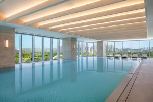 a large swimming pool in a building with windows at Hyatt Regency Xi'An Chanba in Xi'an