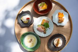 a wooden plate topped with different types of food at Hotel MODA in Yufu