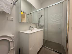 a white bathroom with a sink and a shower at Central Chatswood Urban Stay in Sydney +33 photos