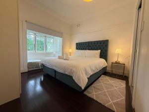 a bedroom with a large bed and a window at Central Chatswood Urban Stay in Sydney
