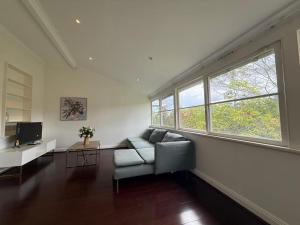a living room with a couch and two windows at Central Chatswood Urban Stay in Sydney