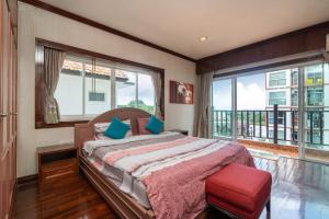 a bedroom with a bed and a large window at Cheeva Pool Villa Phuket in Phuket