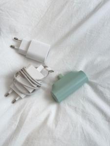 a green and white charger on top of a bed at 지하철 2분, 침대3, 4인 최적, 5인 가능, 홍대 경복궁 명동 동대문 이동편리 in Samgong