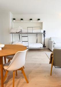 a living room with a table and chairs and bunk beds at Cozy Studio with Pool in Middelkerke 4 Guests in Middelkerke