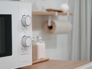a white microwave oven sitting on top of a table at 지하철 2분, 침대3, 4인 최적, 5인 가능, 홍대 경복궁 명동 동대문 이동편리 in Samgong