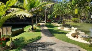 a park with a canal with palm trees and a bridge at LLamados Fishing Lake in San Kamphaeng +28 photos