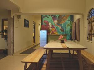 a dining room with a table and a painting on the wall at Kokomo Yogyakarta in Yogyakarta