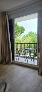 a room with a balcony with a table and a window at Nala Host - Maafushi Homes in Maafushi