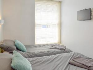 a bedroom with a bed with pillows and a window at Anchor's Away in Filey