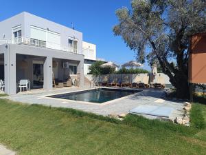a villa with a swimming pool in front of a house at Casa Fountain Villa in Kolymbia