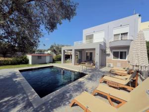 a villa with a swimming pool and patio furniture at Casa Fountain Villa in Kolymbia