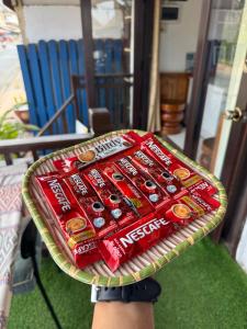 a person holding a tray of endorsed coke cans at Isano Guesthouse in Luang Prabang