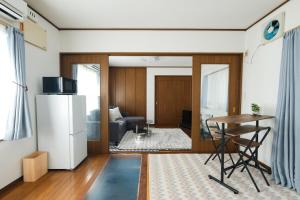 a living room with a table and a kitchen at 空海の宿平生 in Saga