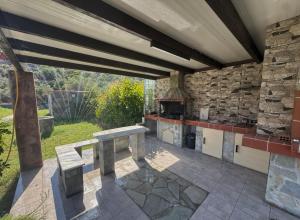 an outdoor kitchen with a table and a stone wall at Casa Fountain Villa in Kolymbia