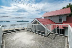 a large deck with a white fence next to a house at 空海の宿平生 in Saga