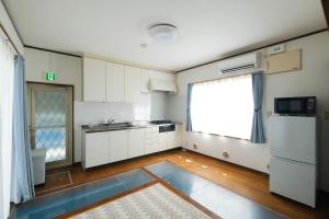 an empty kitchen with a sink and a refrigerator at 空海の宿平生 in Saga