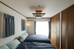 a bedroom with a bed and a large window at 空海の宿平生 in Saga
