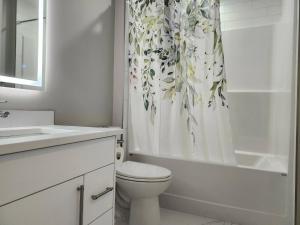 a white bathroom with a toilet and a shower curtain at Harmony Haven in Drumheller in Drumheller +12 photos