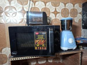 a microwave and a blender on a table at Angel's Cottage in Jaipur