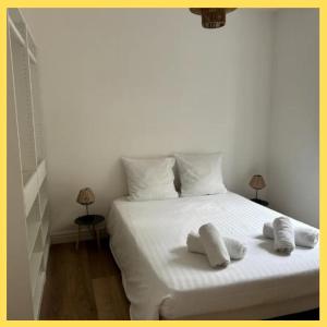 a bedroom with a white bed with two towels on it at La Parenthèse Léman in Neuvecelle