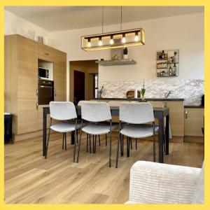 a kitchen and dining room with a table and chairs at La Parenthèse Léman in Neuvecelle