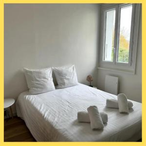 a bedroom with a white bed with two pillows on it at La Parenthèse Léman in Neuvecelle